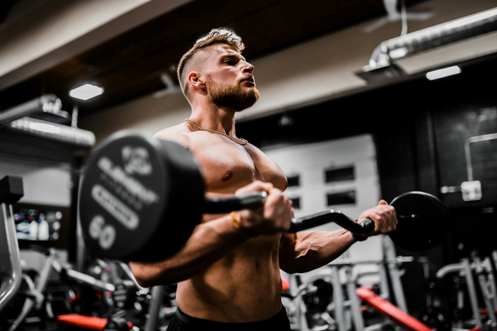 A strong, muscular man training with a barbell in the gym